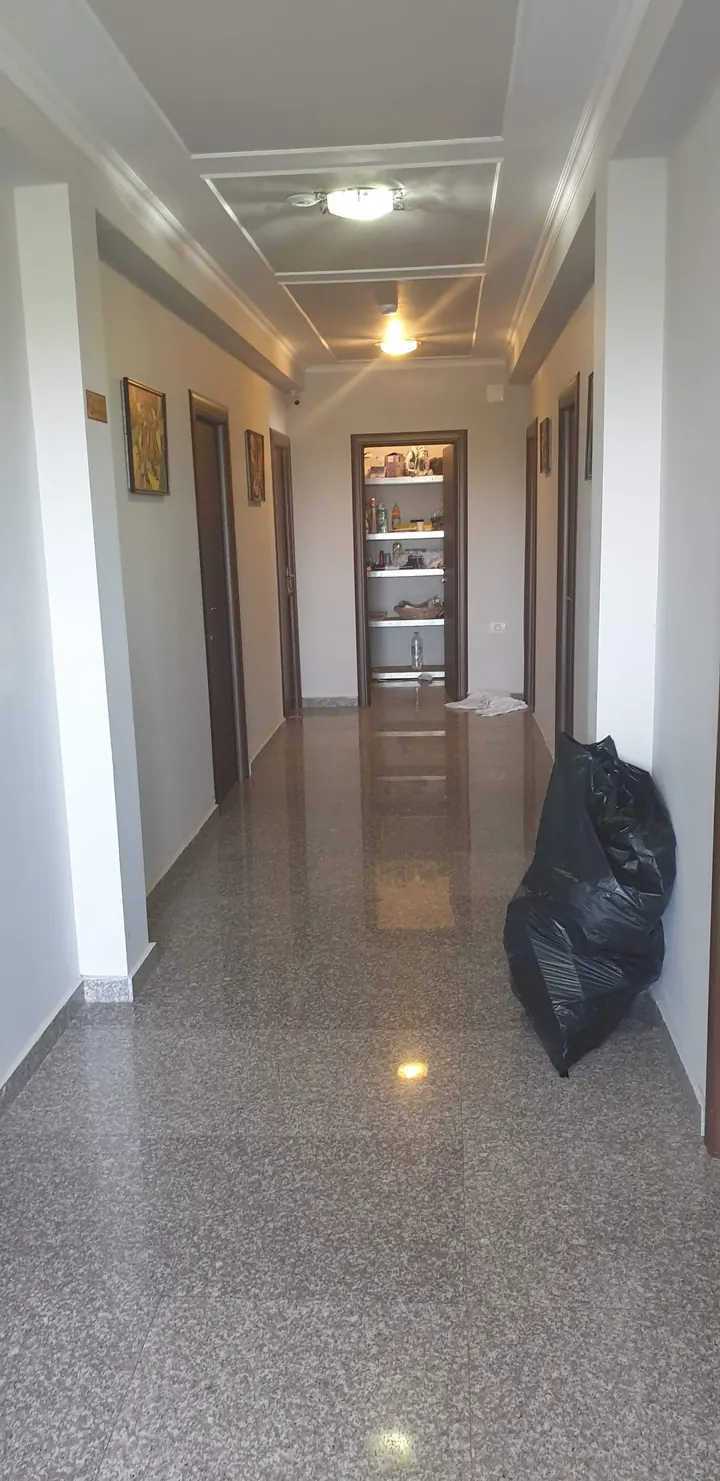 Hol cu pardoseală lucioasă, înainte de editare, cu sac de gunoi și lumină rece.