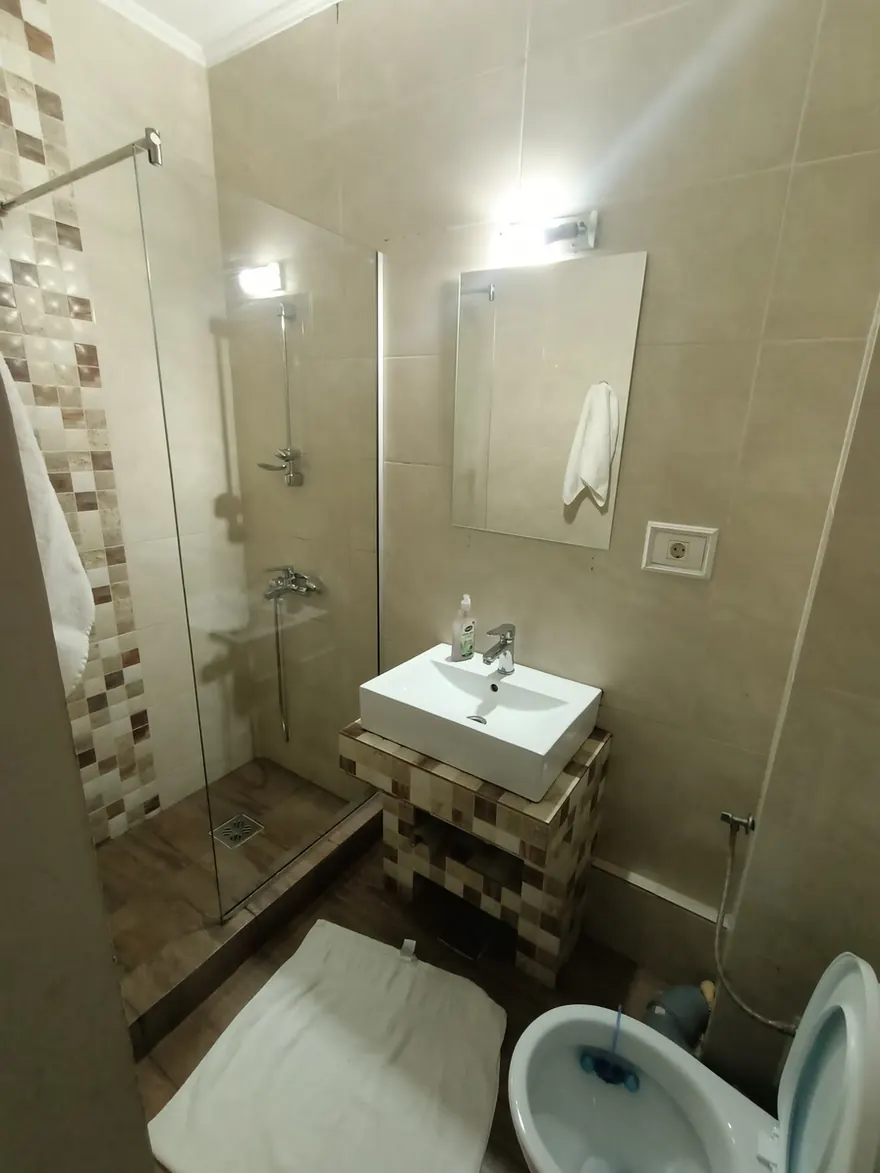 Baie cu duș și lavoar, înainte de editare, cu lumină albă și rece.